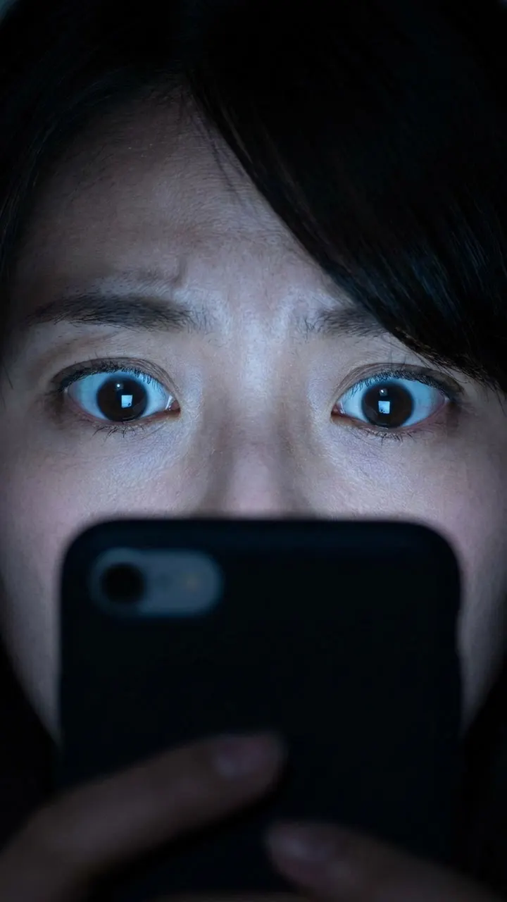 古い携帯の着信音に慌てる結衣。差出人がわからず画面を見つめる場面。